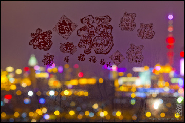 The Phantom of Shanghai night#上海夜魅系列#：二零一二年除夕夜，小姑娘把剪紙貼在客廳的玻璃上做窗花，剛好被我利用拍照做前景，背景是華燈初上的魔都夜景。祝愿大家新的一年福氣、福運高照。摄于大昌街（2012-01-22）