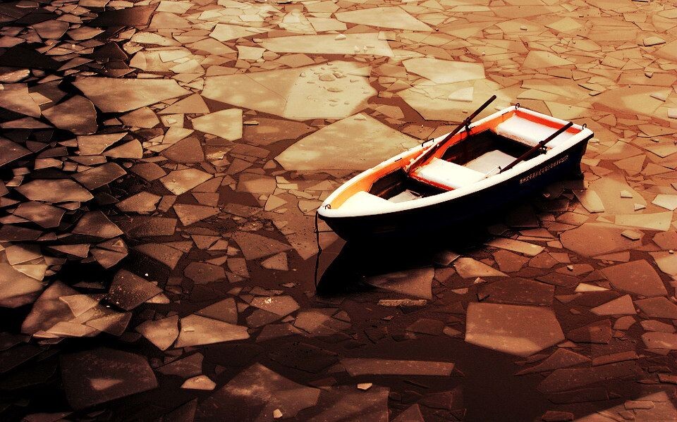 等待一只小船在霞光映照下的冰面上静静地等待,等待春天的到来