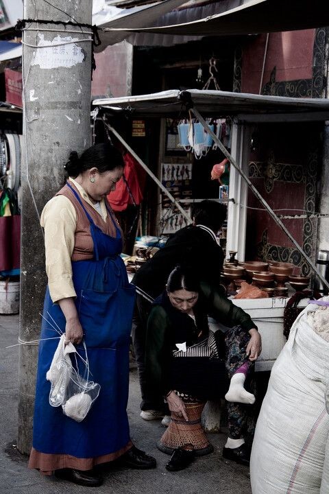 拉萨街拍-讨论鞋垫的妇女