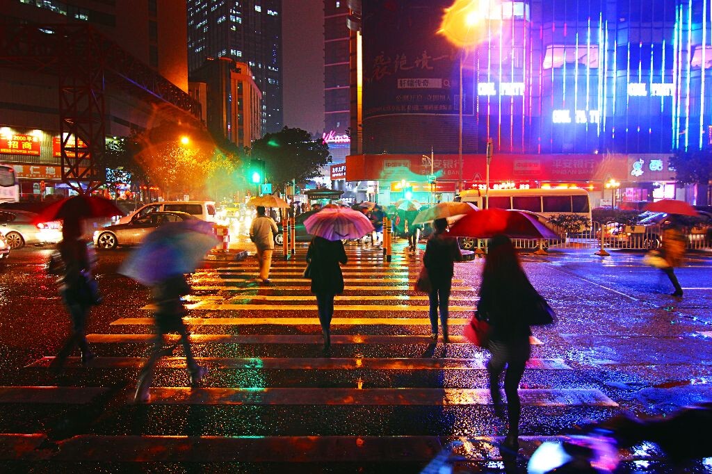 斑驳光影雨天的街道,色彩斑斓,光影斑驳,行人来来往往.