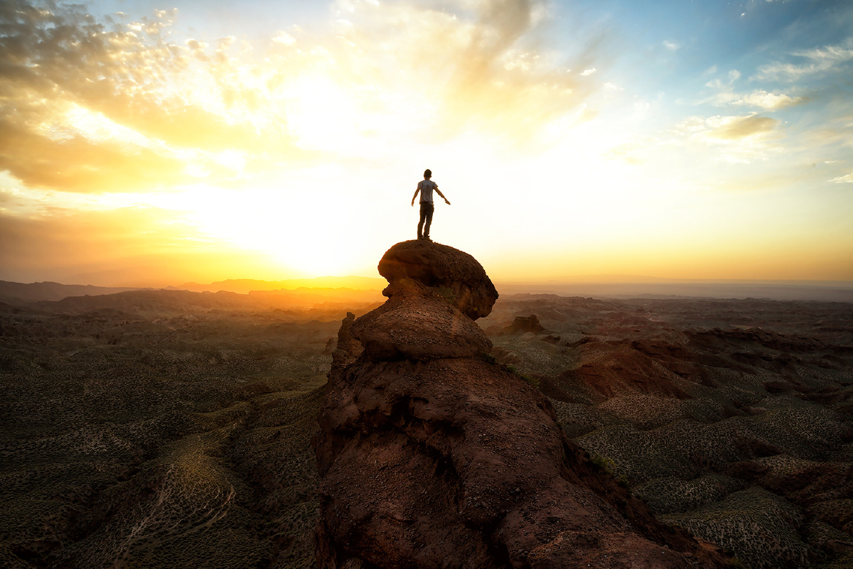 一个人,风很大。三脚架架在了悬崖的边上。只