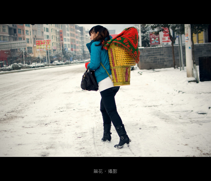 雪中背着小宝宝的妇女