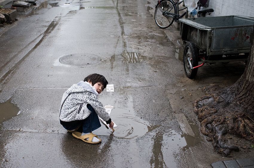 雨后玩水的小孩