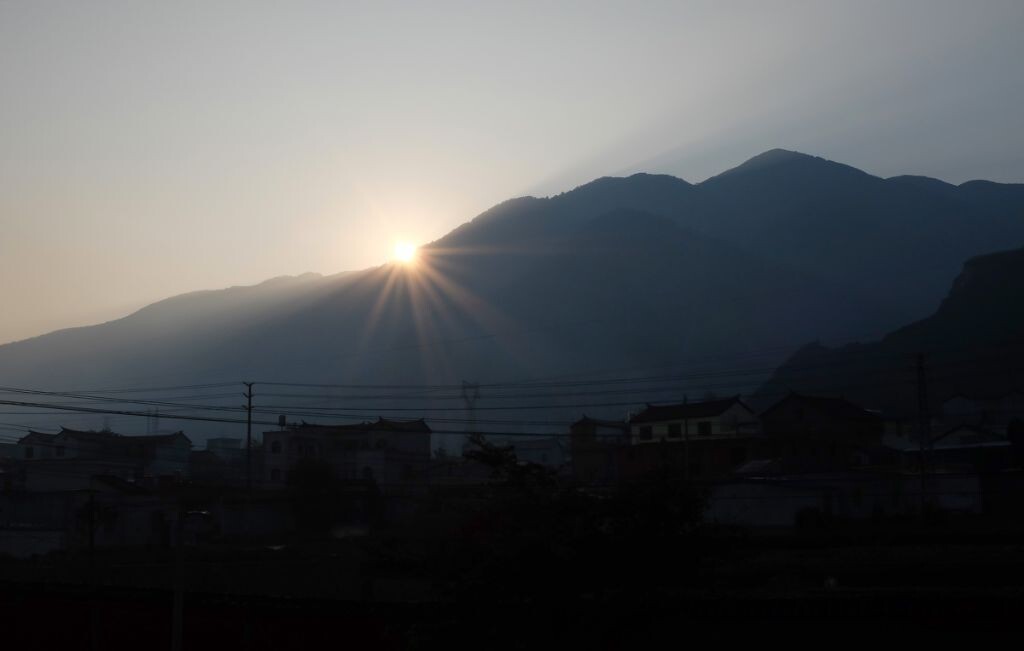 太阳刚"爬上"山,给山下的村庄带来温暖的阳光.