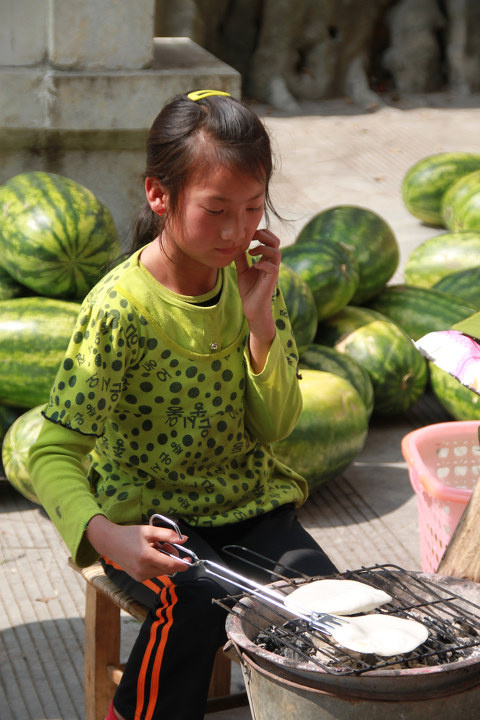 烤粑粑的小女孩