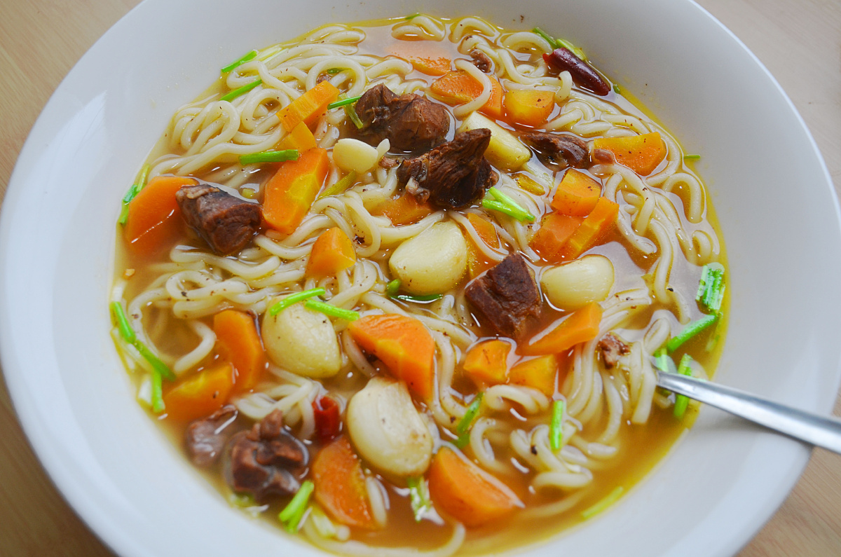 用羊肉汤做底煮的面条,再加入蒜头,胡萝卜和羊肉,难为情吃到最后一滴