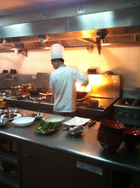 炒菜厨师给酒店堂食的散客在做菜.